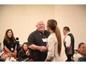 Seagraves High School Principal Daylan Sellers accepts The Moody Foundation grant from Collegiate Edu-Nation Chief Financial Officer Kendall Guynes during the Awards Luncheon at the Rural Empowerment Conference.
